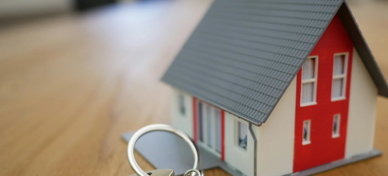 A model house and a set of keys on a wooden table